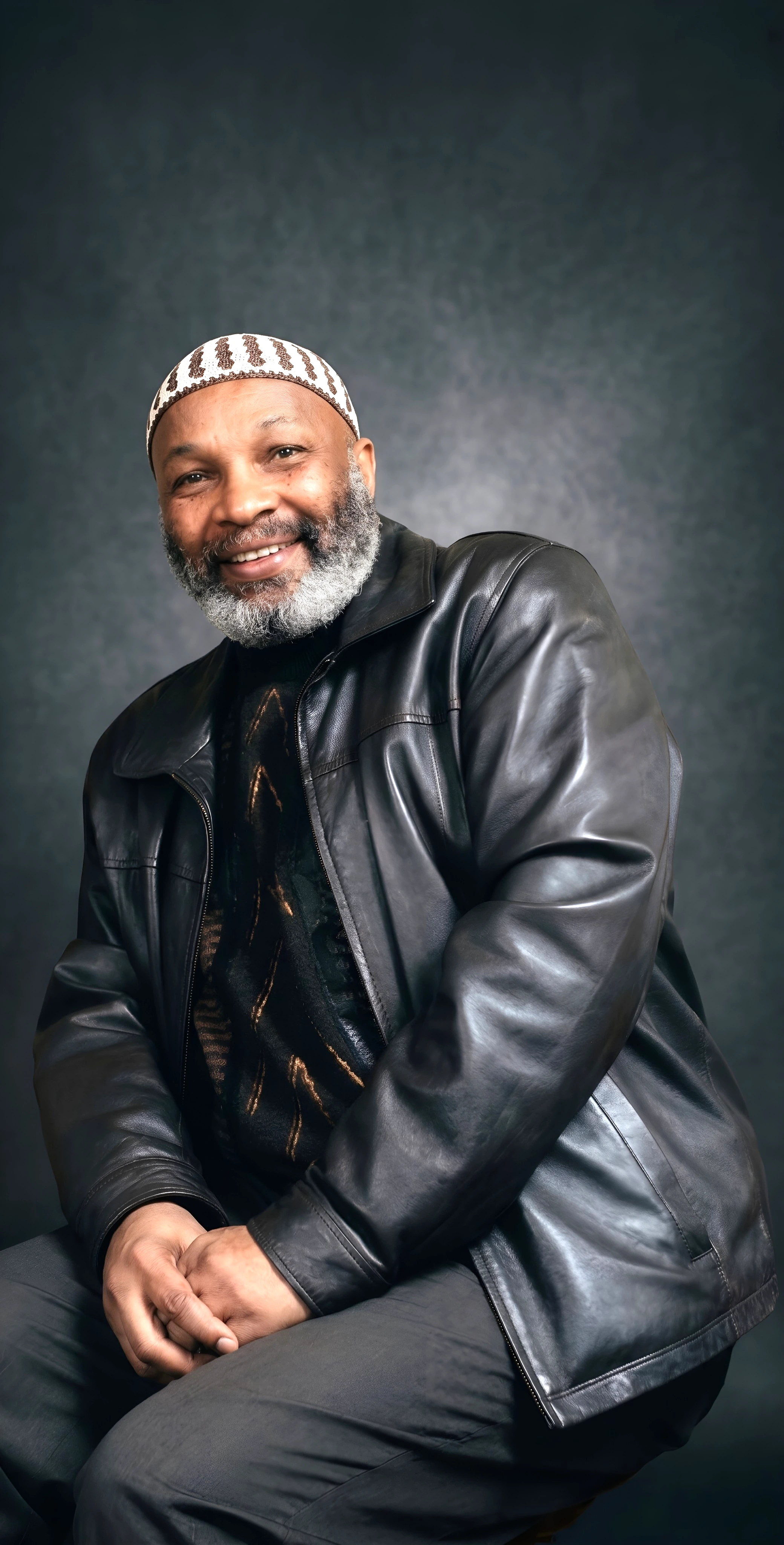 Editorially modified portrait of Abdallah Muhammad wearing a leather jacket and patterned kufi.