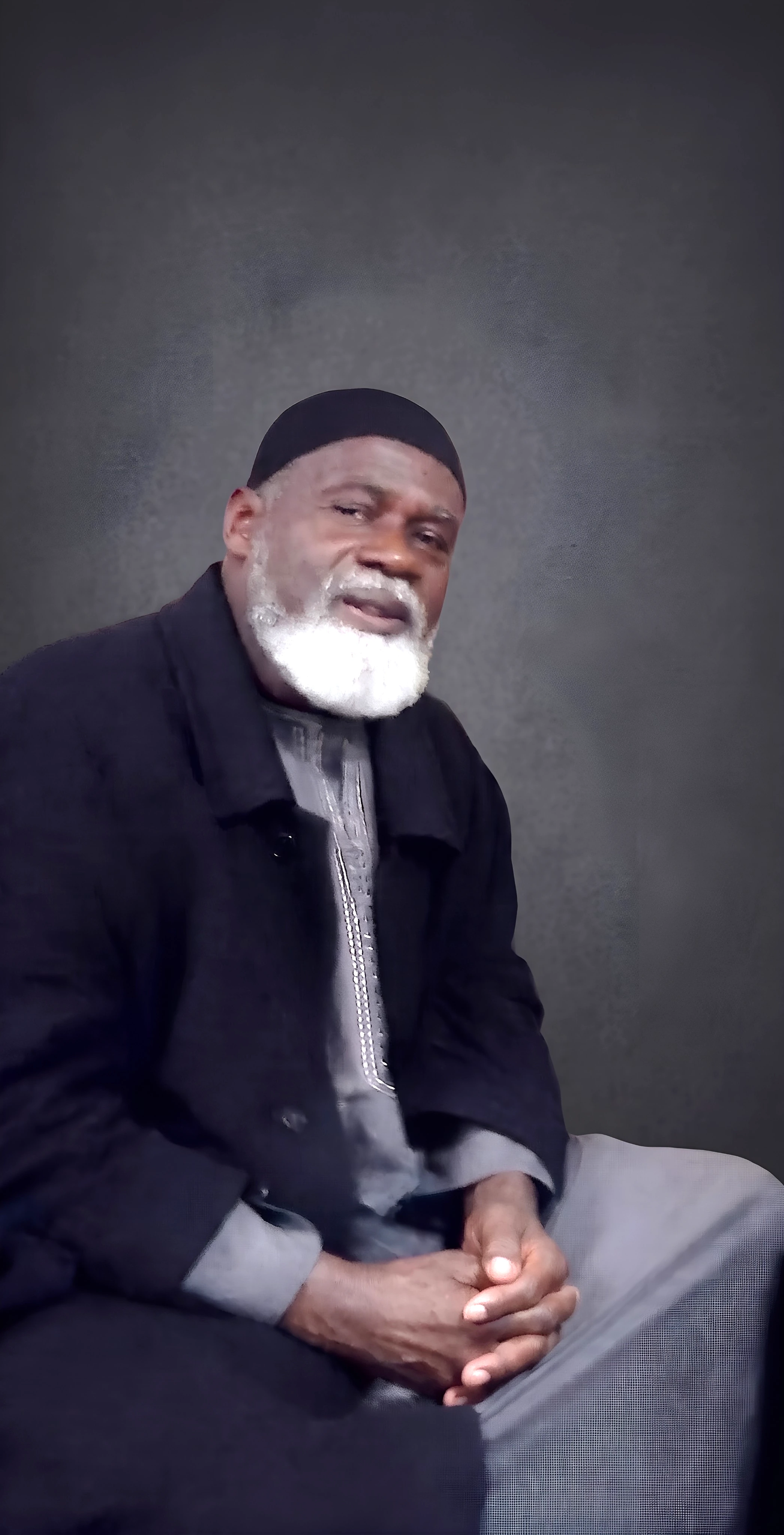 Editorially modified portrait of Imam Aiyub Abdul Baki, wearing a black coat and kufi.