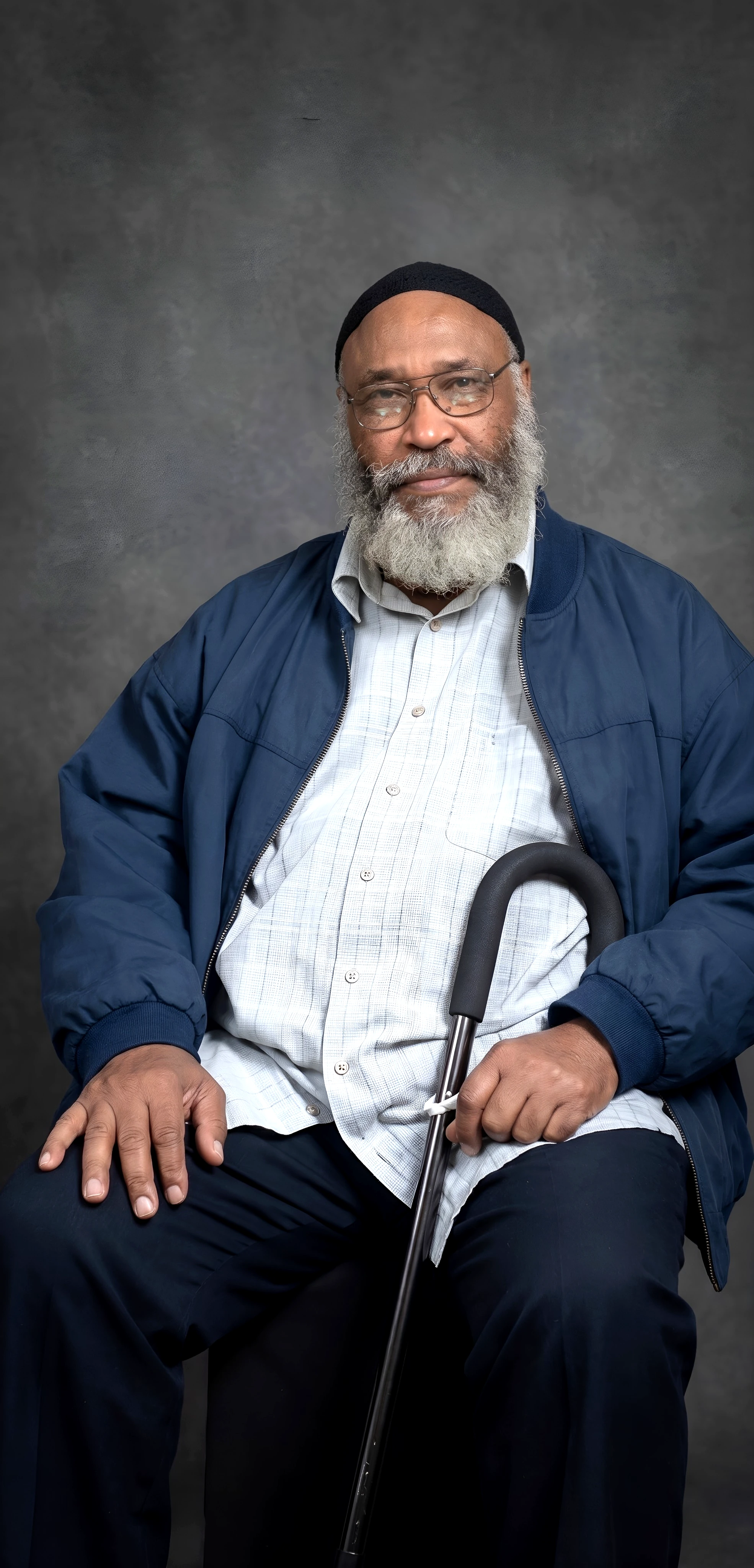Editorially modified portrait of Musa Abdul Rahman with his glasses, blue jacket and cane.
